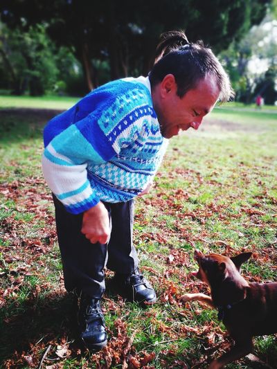 Smiling mature man standing with dog at park