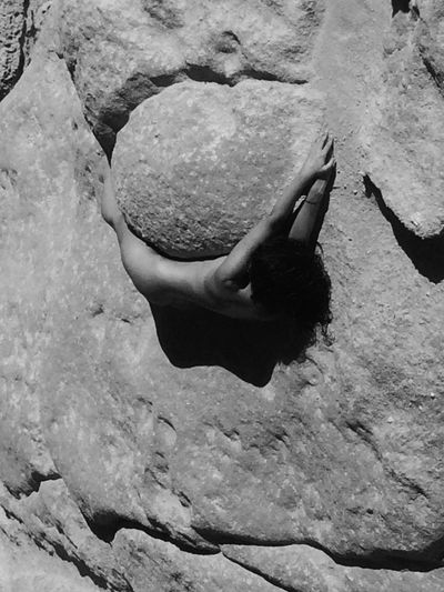 High angle view of young woman on rock at beach