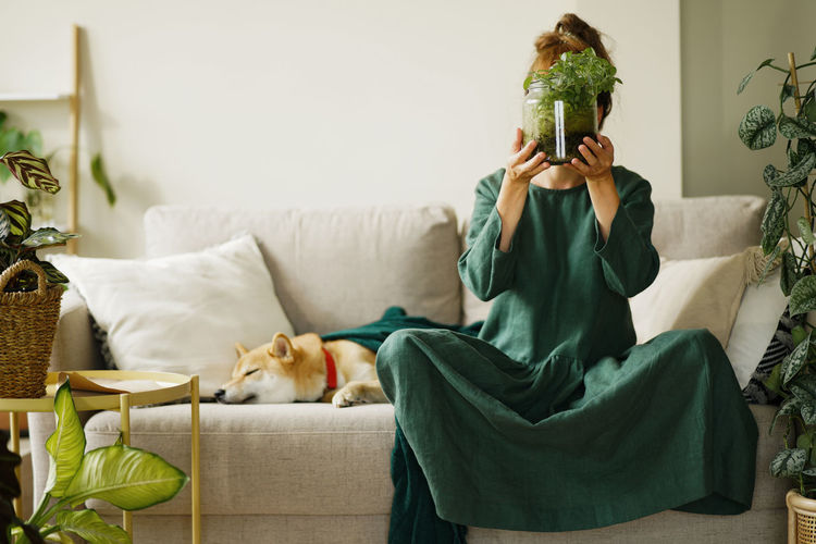 Portrait of young woman sitting on sofa at home