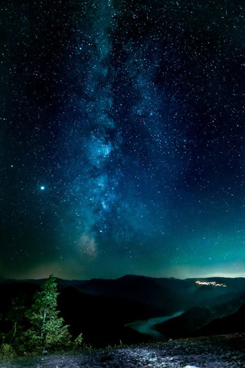 Scenic view of mountains against sky and milky way at night