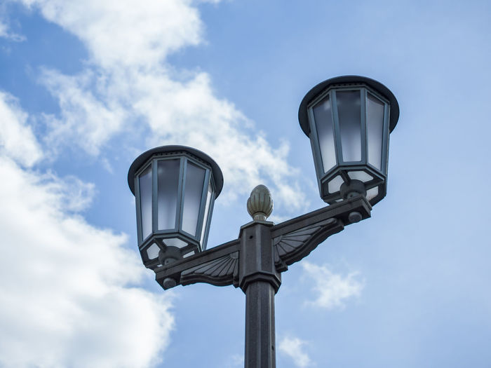 Low angle view of street light at karl marx allee against sky