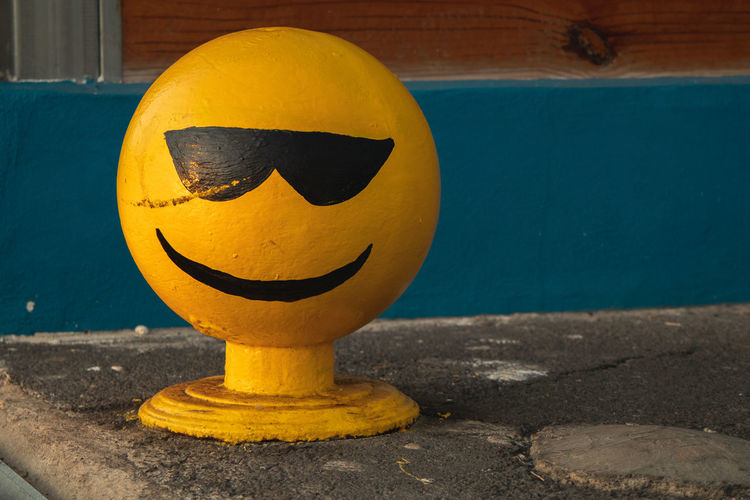 Close-up of smiley face against yellow wall