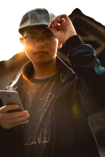 Portrait of young man using mobile phone outdoors