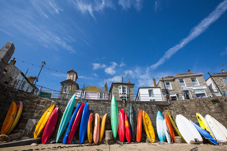 Colorful canoes against sky at beach