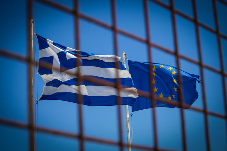 Low angle view of flags against blue sky