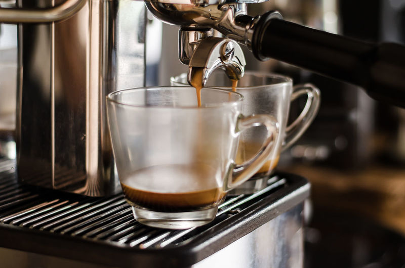 Close-up of coffee maker pouring coffee in cup