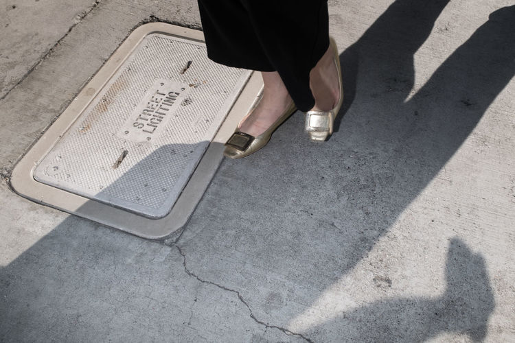 Low section of woman walking on street