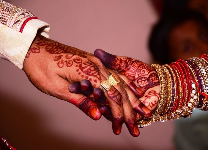 Cropped image of wedding couple holding hands