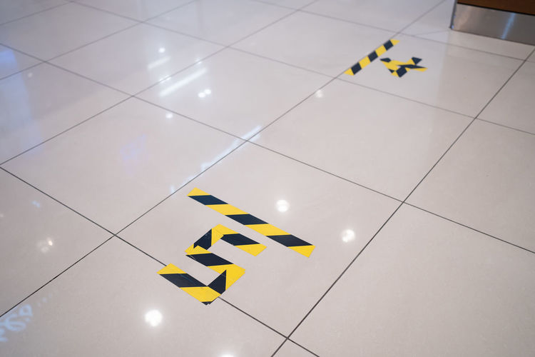 High angle view of yellow flag on tiled floor