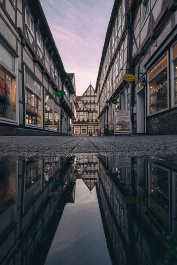 Reflection of buildings in city at sunset
