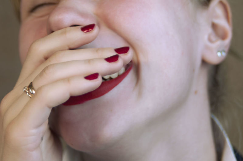 Cropped image of woman laughing while covering mouth