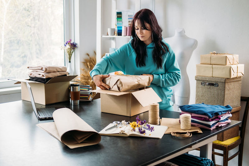 Small business owner, woman hold package box, receiving purchase order, working at office.