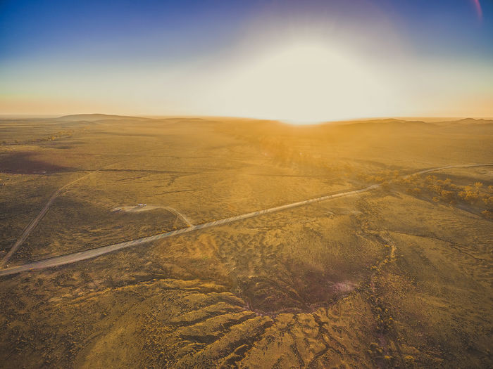Vivid sunset over rural highway passing through desert landscape in south australia aerial shot