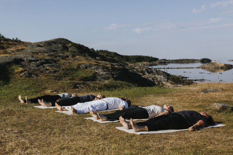 People practicing yoga at coast