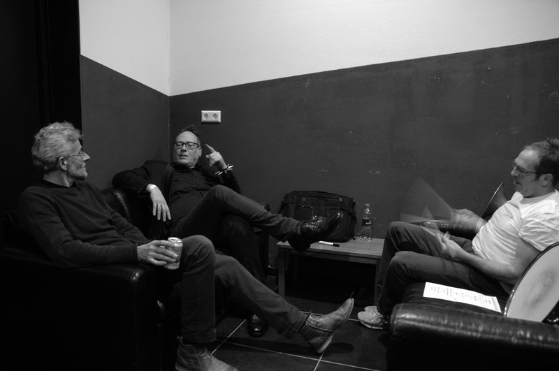 Male friends talking while sitting against wall