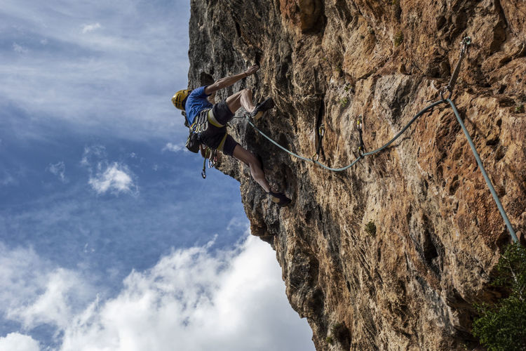 Low angle view of rope on rock against sky