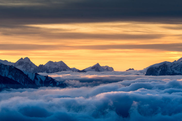 Scenic view of snowcapped mountains against sky during sunset