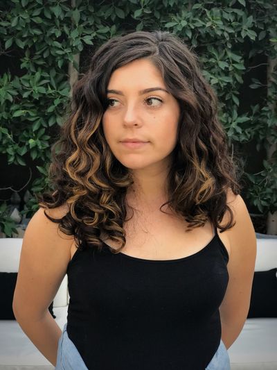 Beautiful young woman standing against plants