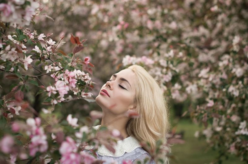 Young woman smelling flowers outdoors