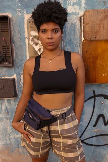 Portrait of woman standing against wall