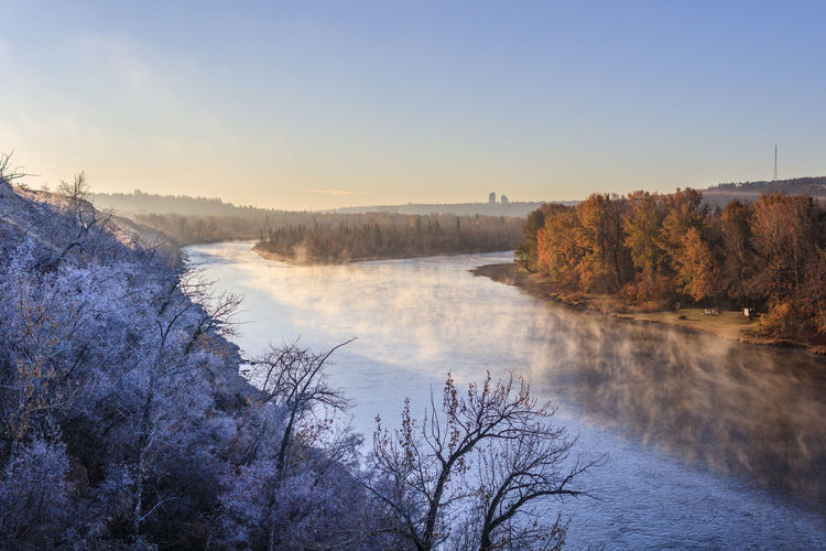 Steamy river flowing through a wintry landscape at dawn