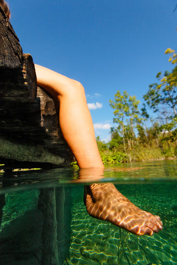 Underwater view of woman legs in plitvice lakes, croatia