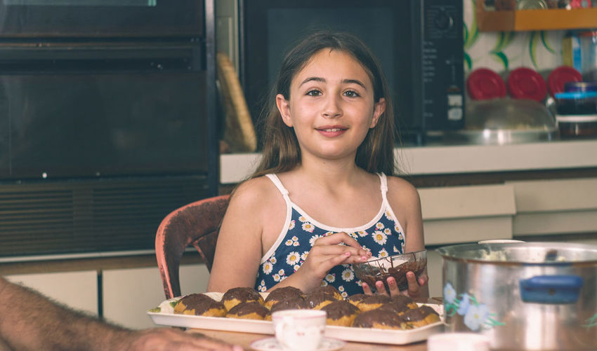 Portrait of girl preparing sweet food in kitchen at home