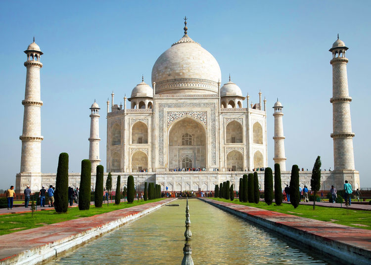 Low angle view of taj mahal in front of reflecting pool against clear sky