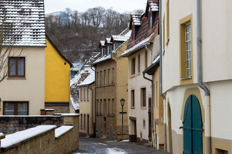 Street amidst houses in city during winter