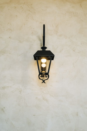 Illuminated light bulb mounted on wall