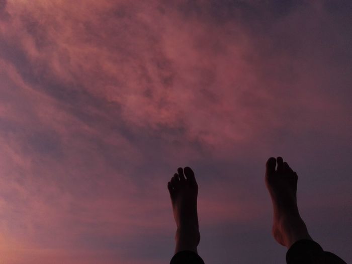 Low section of leg against sky during sunset