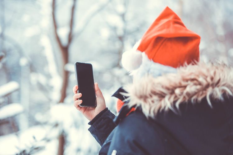 Low section of person photographing with mobile phone in winter