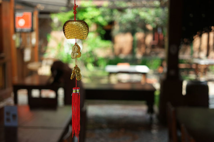 Close-up of electric lamp hanging outside temple