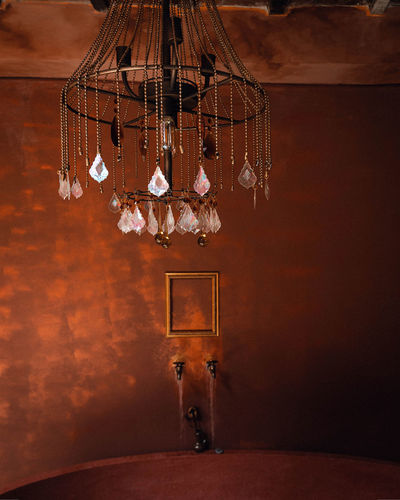 Low angle view of illuminated chandelier hanging on wall