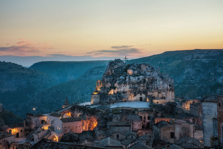 High angle view of rock churches on a hill in matera in italy against sky during sunset