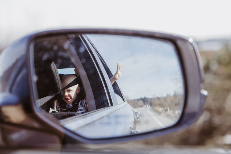 Reflection of woman on side-view mirror