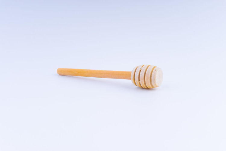 High angle view of honey dipper on white background