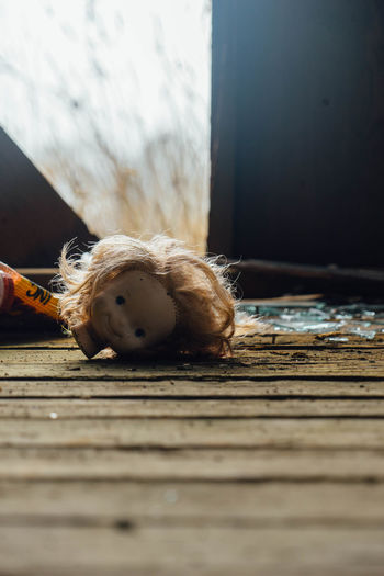 Close-up of damaged doll fallen on floor