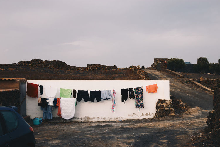Clothes drying on clothesline outside building against sky