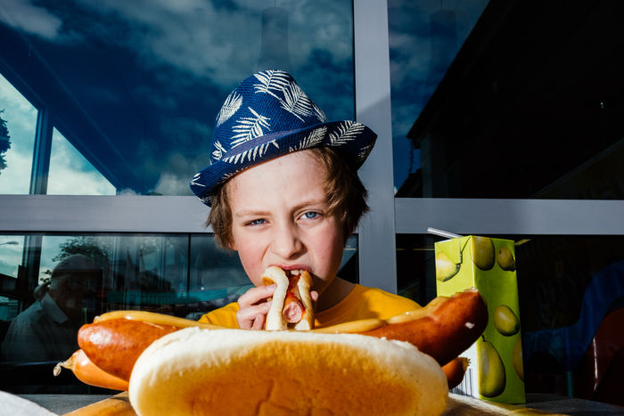 Portrait of boy eating hot dog