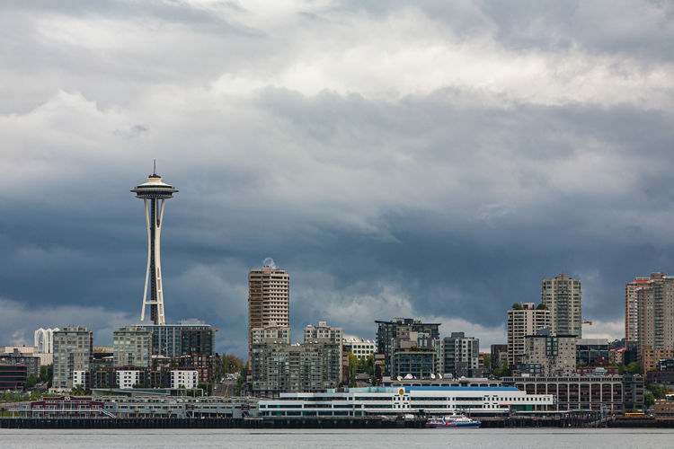 Modern buildings in city against cloudy sky