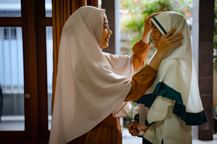 Mother embracing daughter in hijab
