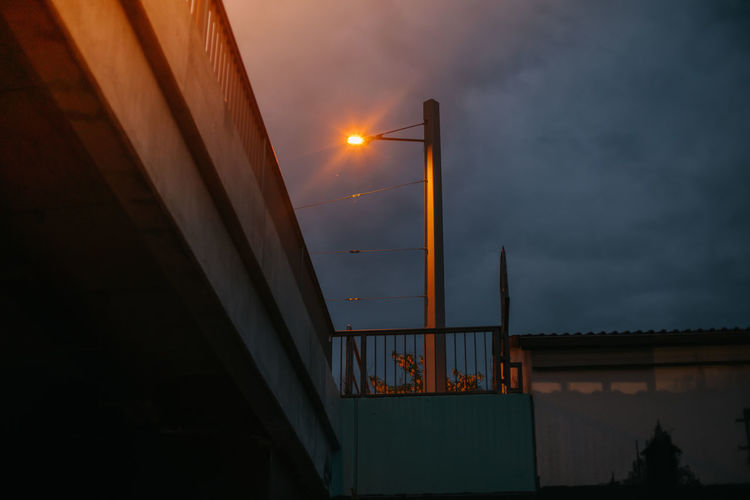 Low angle view of illuminated bridge against sky at sunset