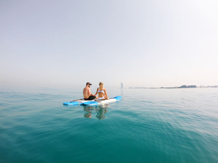 Active couple on the paddle boards with a view on burj al arab