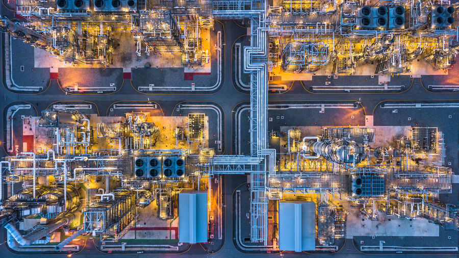 Aerial view of illuminated factory in city at night