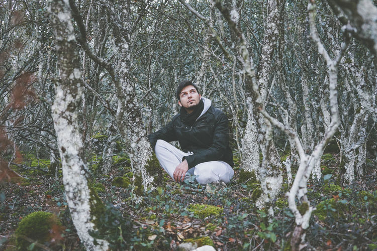 Full length of man sitting in forest