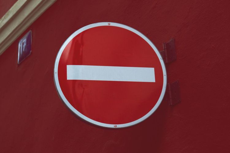 Close-up of sign on red wall