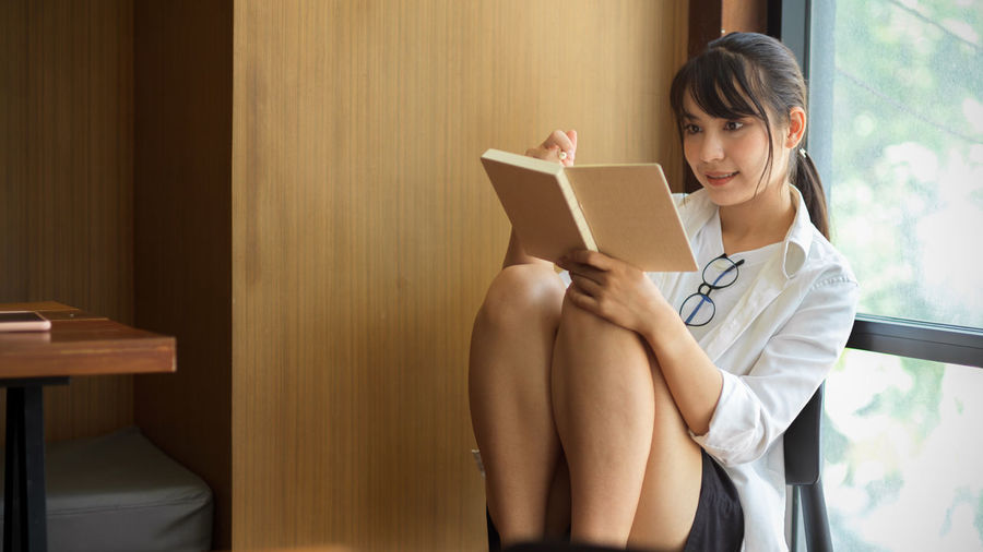 Young woman looking at book