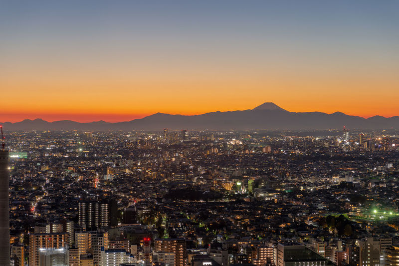 High angle view of illuminated cityscape against sky during sunset
