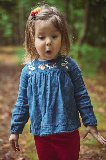 Beautiful baby in an embroidered shirt play in the forest